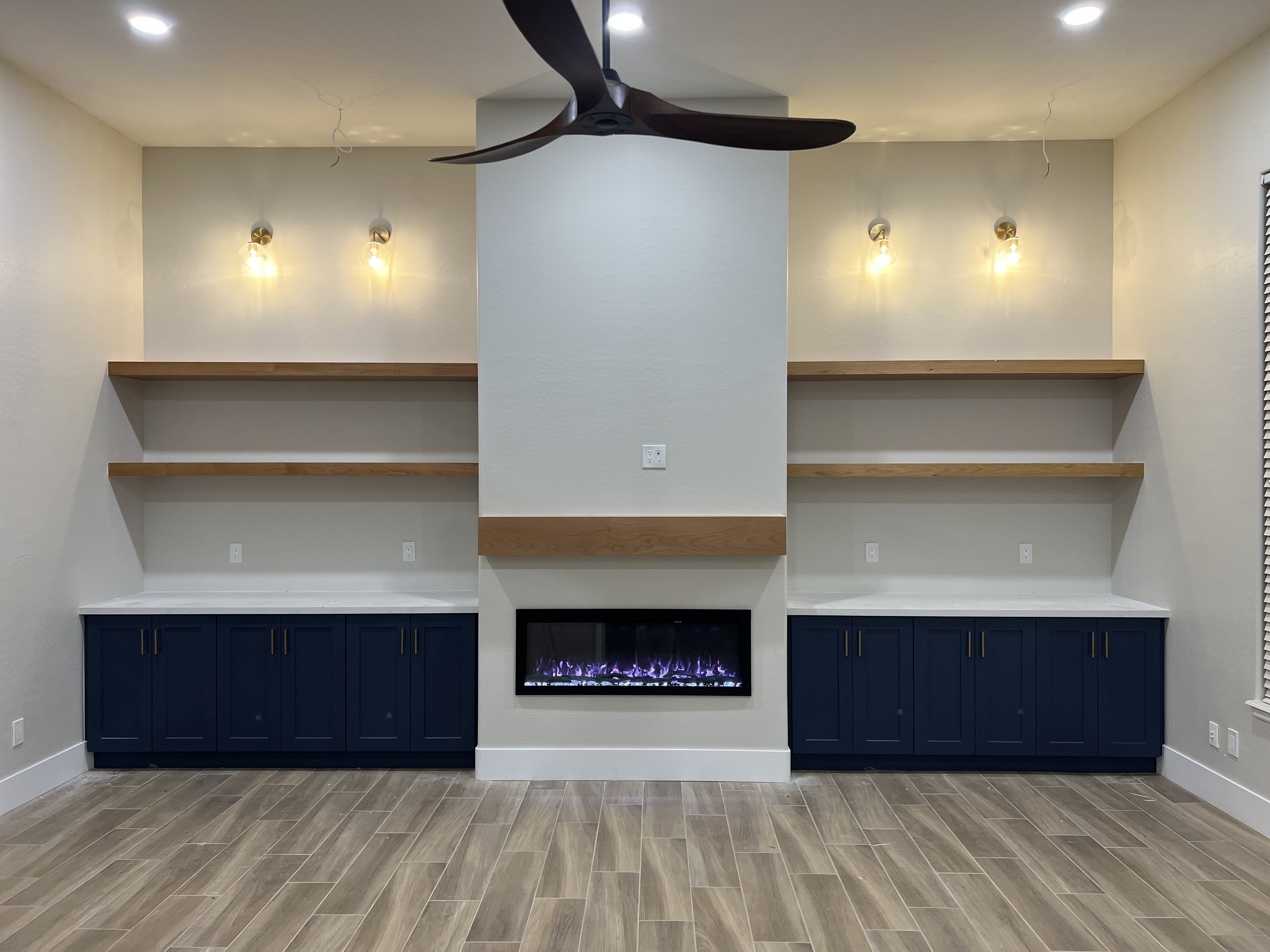Custom built-in shelving and electric fireplace feature wall from a home renovation project